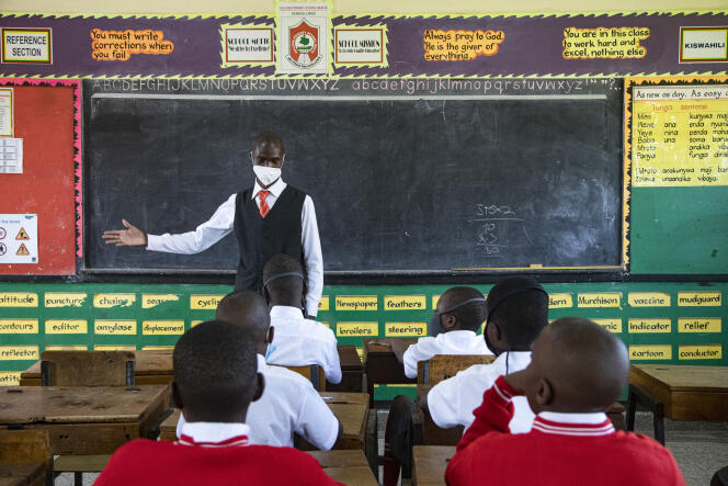 Un enseignant accueille les élèves le jour de la réouverture des écoles, à Kampala (Ouganda), le 10 janvier 2022.