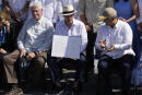 Ecuador's President Guillermo Lasso, center, flanked by former U.S. President Bill Clinton, left, and Colombia's President Ivan Duque, holds a decree that expands the Galapagos Maritime Reserve by 60,000 square kilometers, in Puerto Ayora, Galapagos Islands, Ecuador, Friday, Jan. 14, 2022. (AP Photo/Dolores Ochoa)