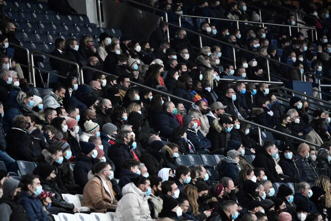 Des supporters parisiens portent le masque en regardant le match de ligue 1 PSG-Brest au Parc des princes, le 15 janvier 2022.