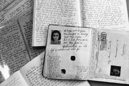 Photo du passeport d’Anne Frank posé sur des cahiers de son journal, qu’elle écrivit  entre juin 1942 et le 4 août 1944.