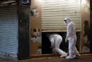 Wildlife officers with personal protective equipment enter a temporarily closed pet shop, after the government announced to euthanize around 2,000 hamsters in the city after finding evidence for the first time of possible animal-to-human transmission of coronavirus disease (COVID-19), in Hong Kong, China, January 18, 2022. REUTERS/Tyrone Siu