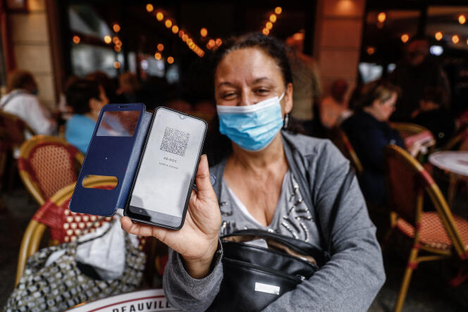 A woman shows her sanitary pass in a brasserie in Deauville (Calvados), July 26, 2021.