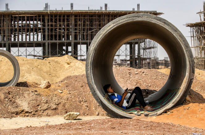 Un ouvrier se repose à l’intérieur d’un tube de béton en se protégeant du soleil sur un chantier de construction du mégaprojet de la « nouvelle capitale administrative » de l’Egypte, à 45 kilomètres à l’est du Caire, le 3 août 2021.