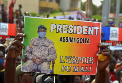 A supporter of Mali's M5-RFP opposition coalition, holds a poster of the colonel Assimi Goita during a rally to mark a year since the start of protest marches that contributed to the ouster of former President Ibrahim Boubakar Keita at the Independence Square in Bamako, Mali June 4, 2021. The poster reads "President Assimi Goita - the hope of Mali". REUTERS/Amadou Keita