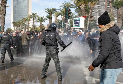 FILE PHOTO: Demonstrators are hit by a water cannon during a protest against Tunisian President Kais Saied's seizure of governing powers, in Tunis, Tunisia, January 14, 2022. REUTERS/Zoubeir Souissi/File Photo