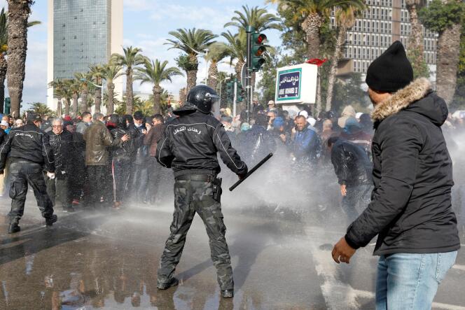 Des manifestants sont visés par un canon à eau lors d’une manifestation contre le président tunisien Kaïs Saïed, à Tunis, le 14 janvier 2022.