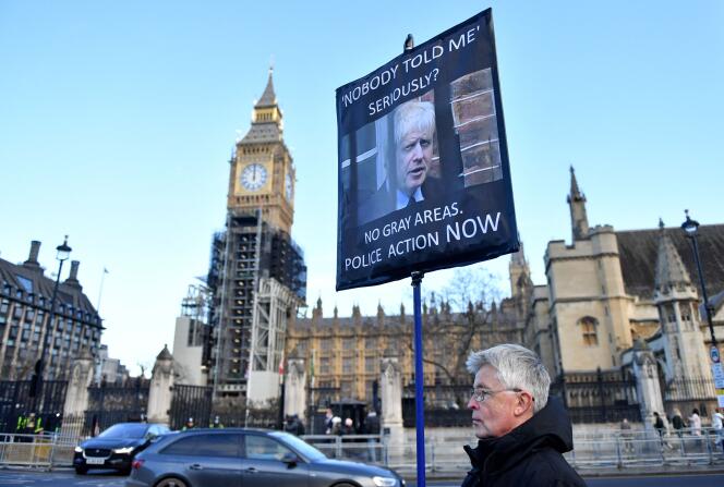 Un manifestant tient une pancarte sur laquelle on peut lire « Personne ne m’a rien dit » alors qu’il proteste devant les Chambres du Parlement à Westminster, dans le centre de Londres, le 19 janvier 2022.