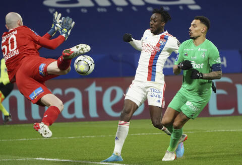 Saint-Etienne's goalkeeper Paul Bernardoni dives for the ball by Lyon's Tino Kadewere, center, Saint-Etienne's Timothee Kolodziejczak during the French League One soccer match between Lyon and Saint Etienne in Lyon, at the Groupama stadium in Lyon, France, Friday, Jan. 21, 2022. (AP Photo/Laurent Cipriani)