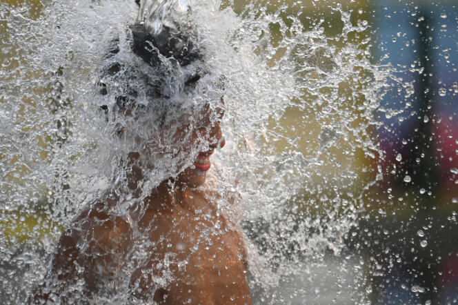 A child tries to cool off during a strong heat wave, in a street in Buenos Aires, January 14, 2022.