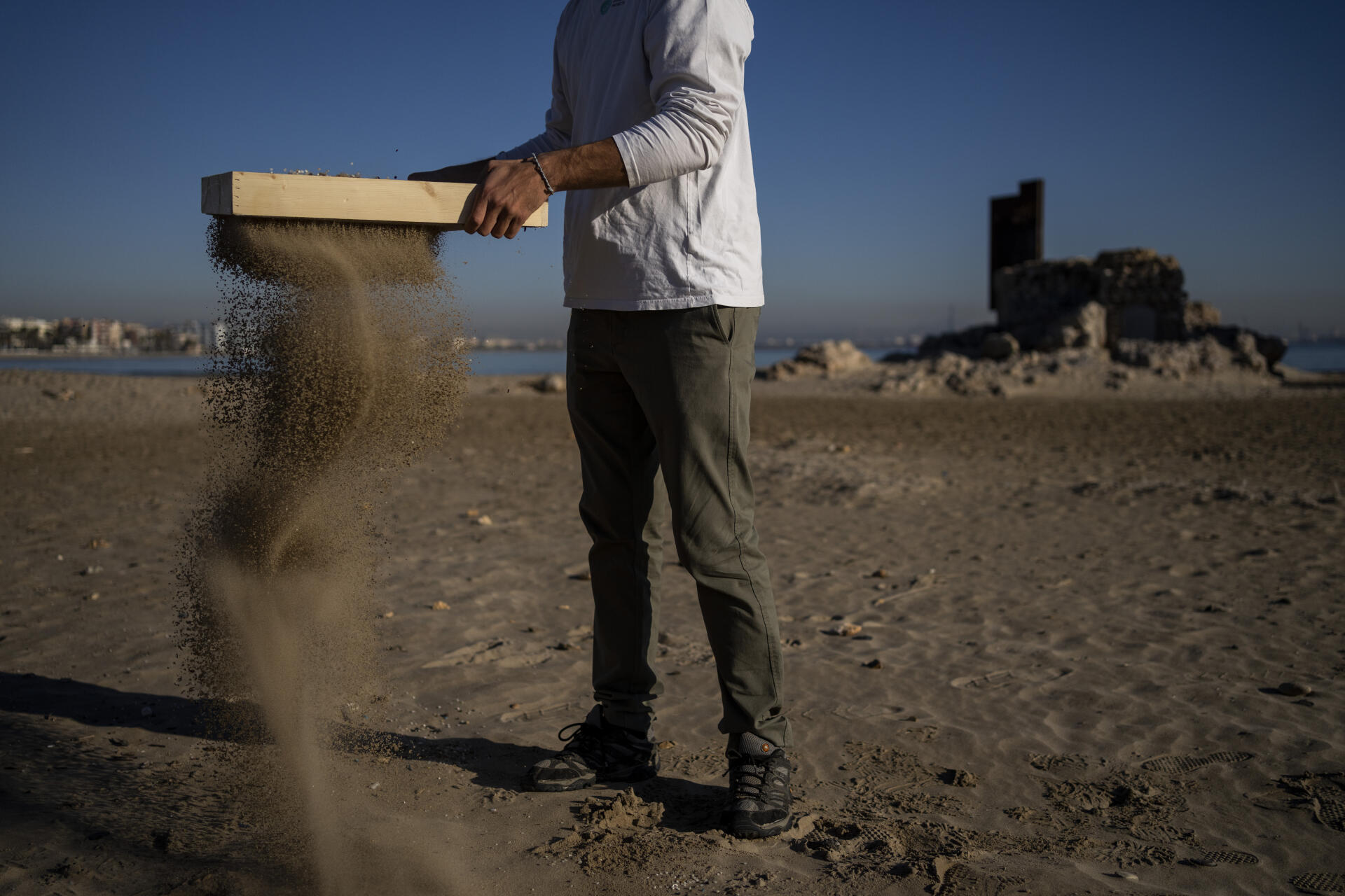 Jordi Oliva, fondateur de l’association Good Karma Projects, collecte des granulés de plastique industriels sur la plage de La Pineda, à Vila-Seca, en Espagne, le 18 janvier 2022.