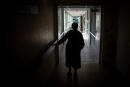 An elderly woman walks along a corridor at the "Residence des Glenans" EHPAD (Establishment for the Housing of Elderly Dependant People) in Haute-Goulaine, outside Nantes, western France on March 30, 2021, amid the crisis linked with the Covid-19 pandemic. (Photo by LOIC VENANCE / AFP)