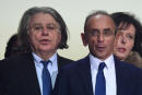 France's far-right party "Reconquete!" leader, media pundit and candidate for the 2022 presidential election Eric Zemmour (R) stands next to French lawyer Gilbert Collard (L) at the Palais des Victoires during a meeting as part of a campaign trip in the Alpes-Maritimes region in Cannes, south eastern France, on January 22 2022. - Between judicial news, hectic travel and backlash in the polls, the presidential campaign of Eric Zemmour is going through a period of turbulence after he arrived in Nice on January 21, 2022 and began a trip to the Alpes-Maritimes, to Menton and Antibes, before a meeting on January 22, 2022 in Cannes, where he hopes to gather 4,000 people. (Photo by BERTRAND GUAY / AFP)