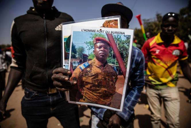 A Uagadugú, 25 de marzo de enero, un homme brandit un retrato del teniente coronel Paul Henri Sandaogo Damiba qui a pris a pris le pouvoir au Burkina Faso la veille.
