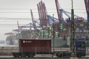 A truck drives past huge container ships in the port of Hamburg (northern Germany) on January 19, 2022.