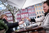 Deux femmes trinquent à la terrasse d’un café, à Copenhague, en avril 2021.