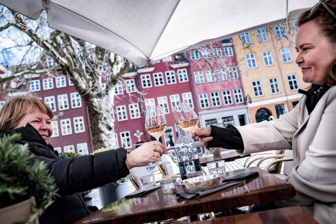 In April 2021, two women press the glass on the terrace of a hotel in Copenhagen.