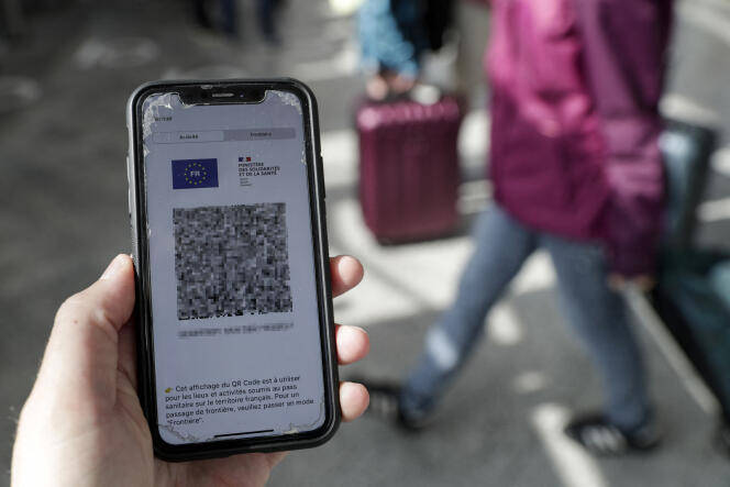 Un passager montre son passe sanitaire sur son téléphone portable, à la gare de Lyon, à Paris, en août 2021.
