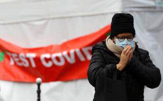 Una persona, che indossa una maschera protettiva, passa davanti a una tenda per il test rapido della malattia del coronavirus (COVID-19) nelle strade di Parigi, in mezzo alla pandemia della malattia del coronavirus (COVID-19), Francia, 31 gennaio 2022. REUTERS/Violeta Santos Moura