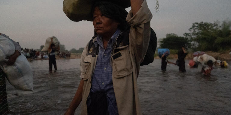 An elderly displaced villager is trying to cross the Moei River into Thailand during the Burmese military’s shells in Palu village, Karen State, Myanmar on December 19, 2021. As the Thai authority immediately stop villagers in the middle of the crossing.