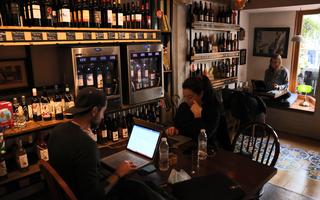 I libanesi si siedono con i loro laptop in un caffè a Beirut il 14 gennaio 2022. - La musica è spesso attutita e l'atmosfera è studiosa - per gli avventori che riempiono i caffè di Beirut in questi giorni, le cose più importanti sono una buona illuminazione e un wi-fi stabile . Questo perché ora fungono da posti di lavoro sostitutivi per le persone alle prese con la drastica carenza di elettricità e i tagli a Internet derivanti dall'incessante crisi economica del Libano. (Foto di JOSEPH EID / AFP)