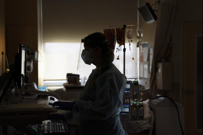 En un hospital de Los Ángeles, una enfermera en la cama con un paciente que sufre de Govt-19.