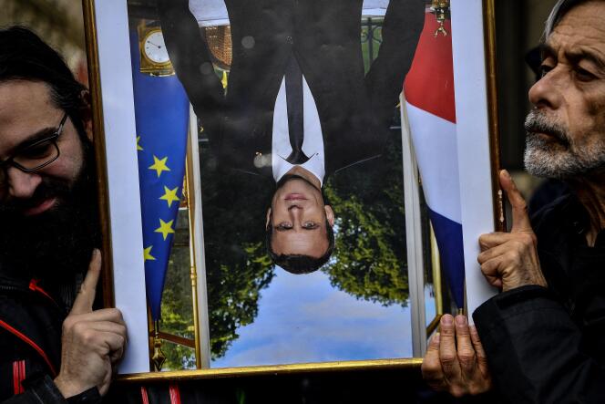 Des décrocheurs de portraits d’Emmanuel Macron, dans le cadre d’une action du groupe ANV-COP21 (Action non violente-COP21), à Paris, le 13 mars 2020.