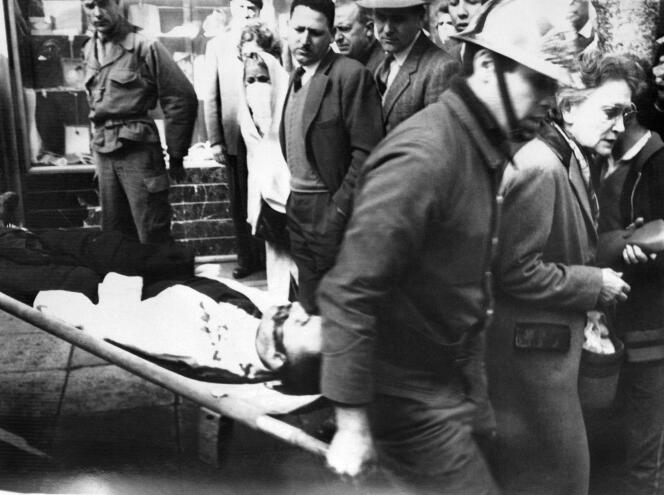 Evacuation d’une victime après un attentat de l’OAS contre une pharmacie à Alger, le 17 mars 1962.