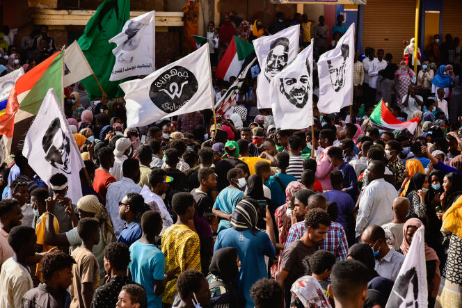 Lors d'une manifestation en hommage à Mohammed Yousif, des drapeaux flottent avec des photos de lui, le 3 février 2022 dans le quartier de Wood Nawboy, à Khartoum, au Soudan.