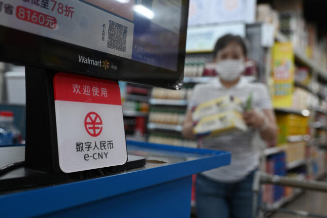 Dans un magasin Walmart, à Pékin, en juillet 2021, le signe affiché sur cette caisse précise que les paiements en yuans numériques (e-CNY), alors en phase de test, sont acceptés.
