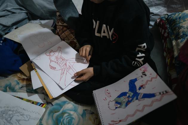 Le petit frère de Sophia montre ses dessins, dans le camp de Roj, le 9 février 2022.
