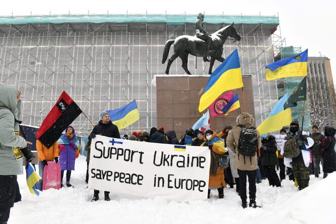 Des manifestants agitent des drapeaux ukrainiens lors d’une manifestation pour  « Soutenir l’Ukraine », devant la statue de l’ancien président finlandais, Carl Gustaf Mannerheim, dans le centre d’Helsinki, le 5 février 2022.