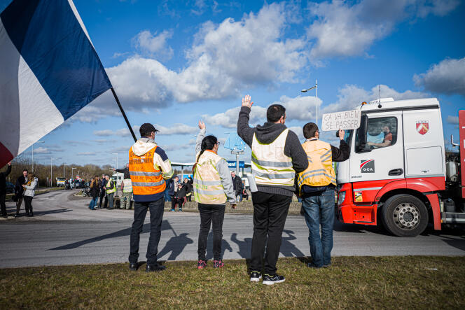 Des manifestants portant des gilets jaunes encouragent les caminonneurs du « convoi de la liberté », à Glisy (Hauts-de-France), le 11 février 2022.
