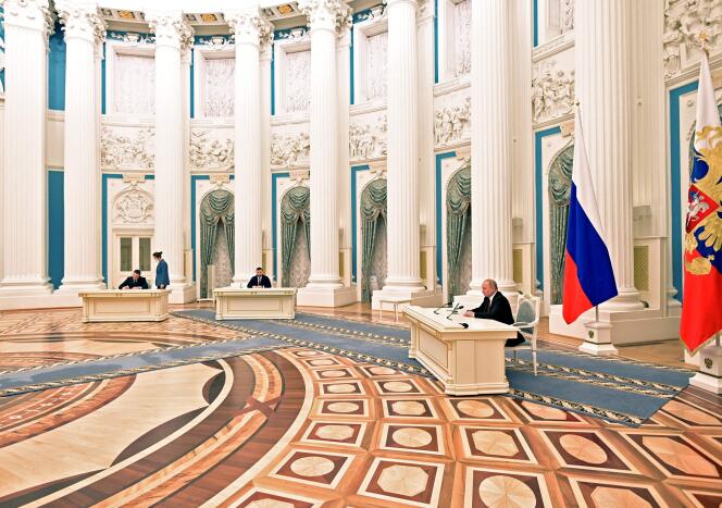 Le président russe, Vladimir Poutine, signant des décrets de soutien aux provinces ukrainiennes prorusses, au Kremlin, à Moscou, le 21 février 2022.