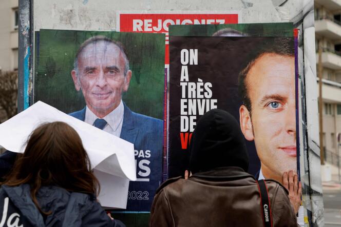 Des militants des Jeunes avec Macron collent des affiches pour appeler le président de la République en exercice à se présenter à sa propre succession, à Issy-les-Moulineaux, le 18 février 2022.