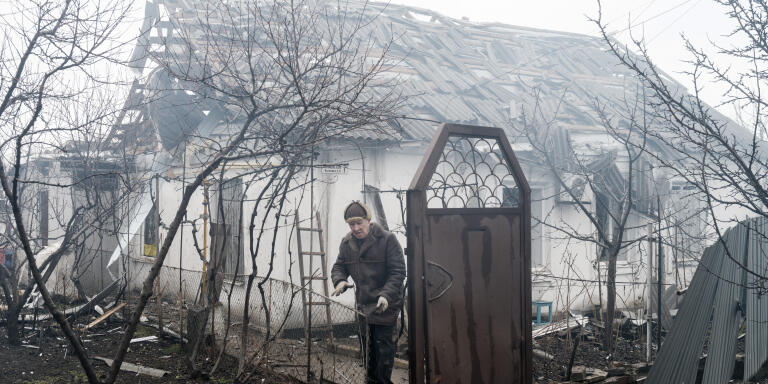 UKRAINE. Mariupol. 24 February 2022 .A civilian evacuates his burning house.