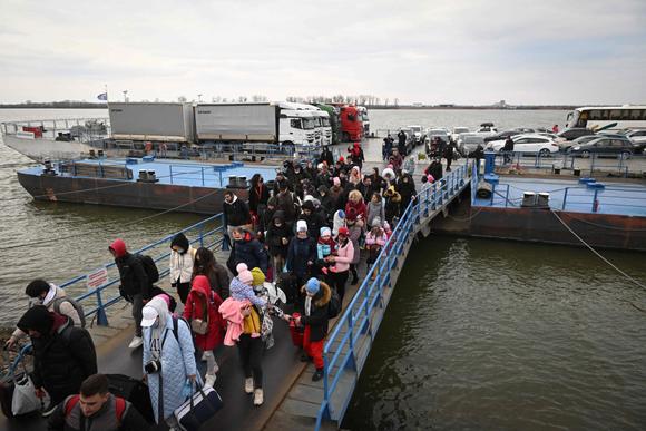 Des Ukrainiens descendent d’un ferry pour entrer en Roumanie après la traversée du Danube au poste frontière d’Isaccea-Orlivka, le 26 février 2022.