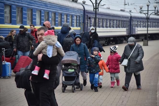 Des passagers, dont des personnes évacuées des villes de Sumy et de Kiev, marchent sur le quai d’une gare à leur arrivée à Lviv, en Ukraine, le 25 février 2022.