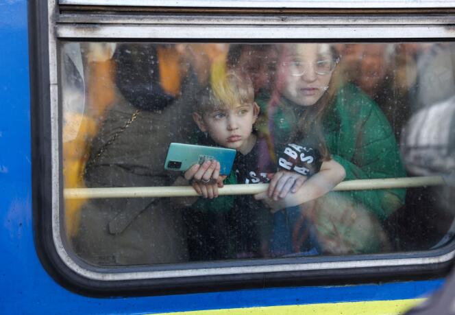 Une femme et son fils regardent la sortie d’un train d’évacuation de Kiev à Lviv à la gare centrale de Kiev, Ukraine, 25 février 2022.