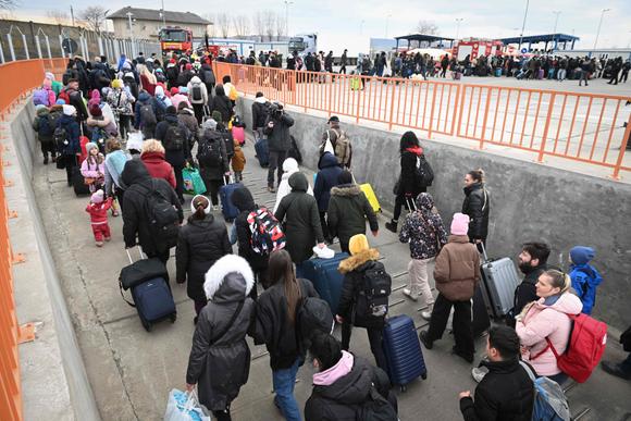 Des Ukrainiens descendent d’un ferry pour entrer en Roumanie après avoir traversé le Danube au poste frontière d’Isaccea-Orlivka, le 26 février 2022.
