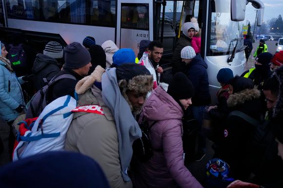 Des réfugiés fuyant le conflit en Ukraine montent dans un bus à leur arrivée à Przemysl, en Pologne, dimanche 27 février 2022.