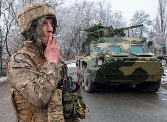 Un soldat ukrainien devant un véhicule blindé à l’extérieur de Kharkiv, en Ukraine, le 26 février 2022.