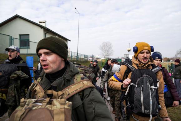 Un groupe d’hommes ukrainiens, rentrant en Ukraine pour aider à se défendre contre l’invasion russe, au poste-frontière de Medyka, en Pologne, le 27 février 2022.