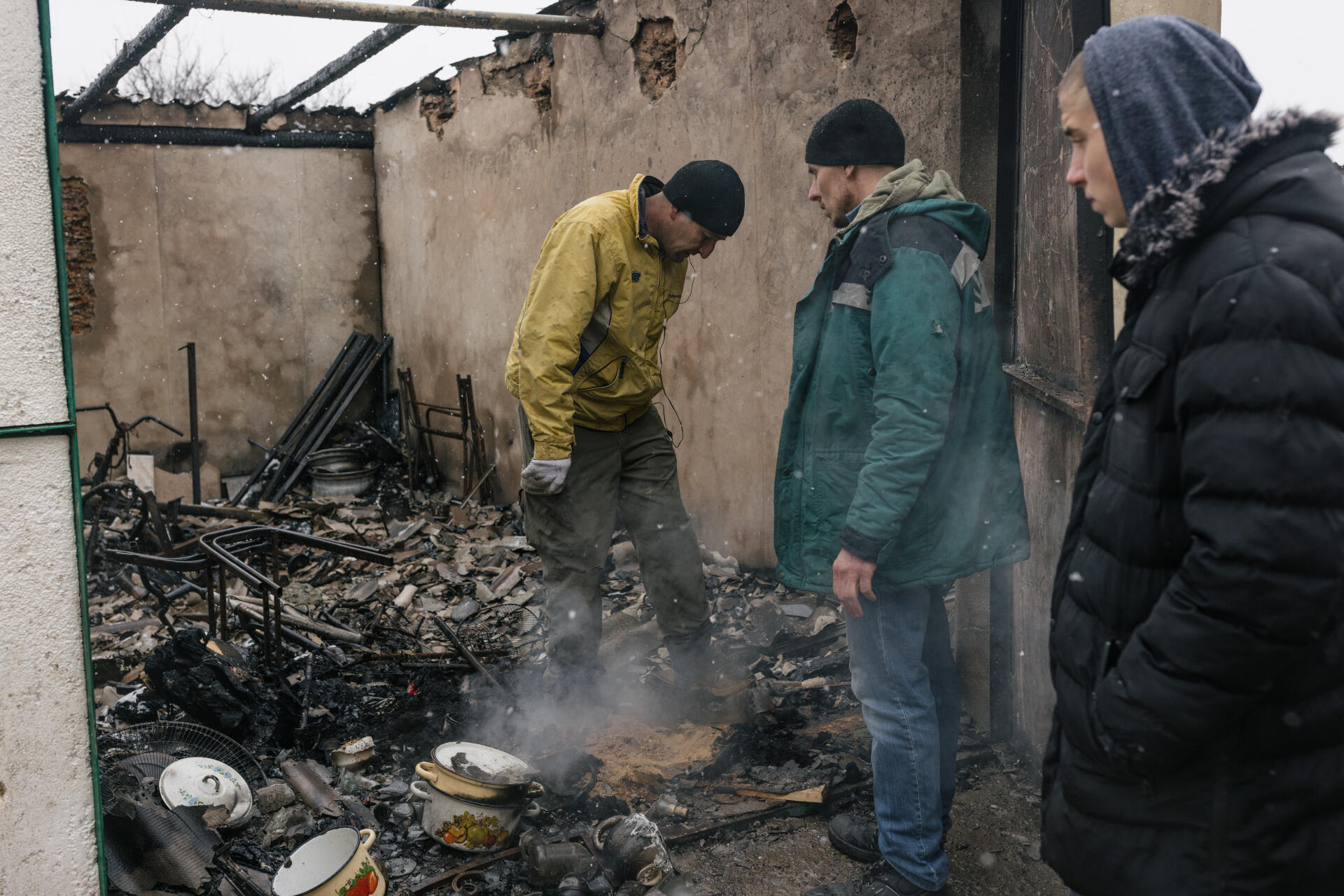 Des ouvriers entrent dans une maison endommagée par des missiles russes tombés la veille, dans le village de Datchne, près d’Odessa, le 2 mars 2022.