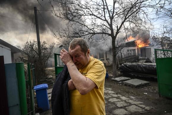 Yevghen Zbormyrsky, 49 ans, devant sa maison en feu après le bombardement de la ville d’Irpin, en banlieue de Kiev, le 4 mars 2022.