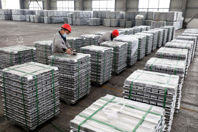 Employees work with aluminum ingots in Huaibei, China, February 9, 2022. 