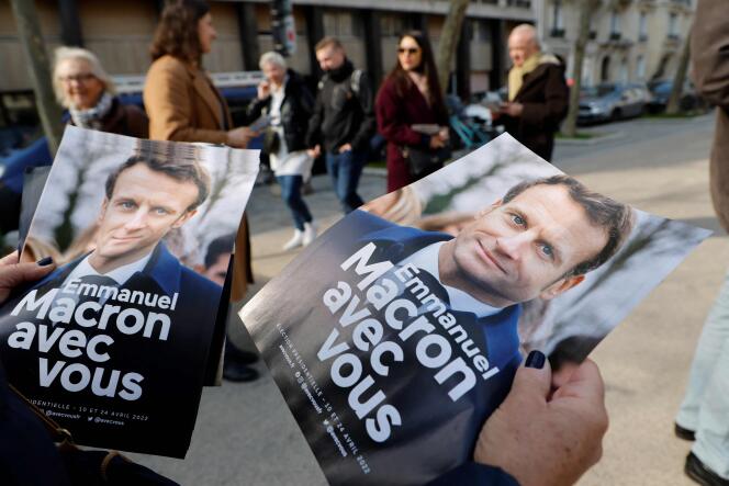 Voluntarios de La République en Marche distribuyen folletos de campaña a favor de su candidato presidencial, el jefe de Estado saliente, Emmanuel Macron, en un mercado de París el 5 de marzo de 2022.