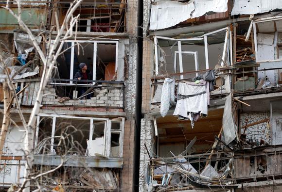 Un habitant regarde la façade détruite d’une pièce d’un bâtiment à plusieurs étages qui a été gravement endommagé par l’explosion d’un missile russe, après qu’il ait été abattu au-dessus de la ville par la défense aérienne ukrainienne le 6 mars, à Kramatorsk, le 7 mars 2022.