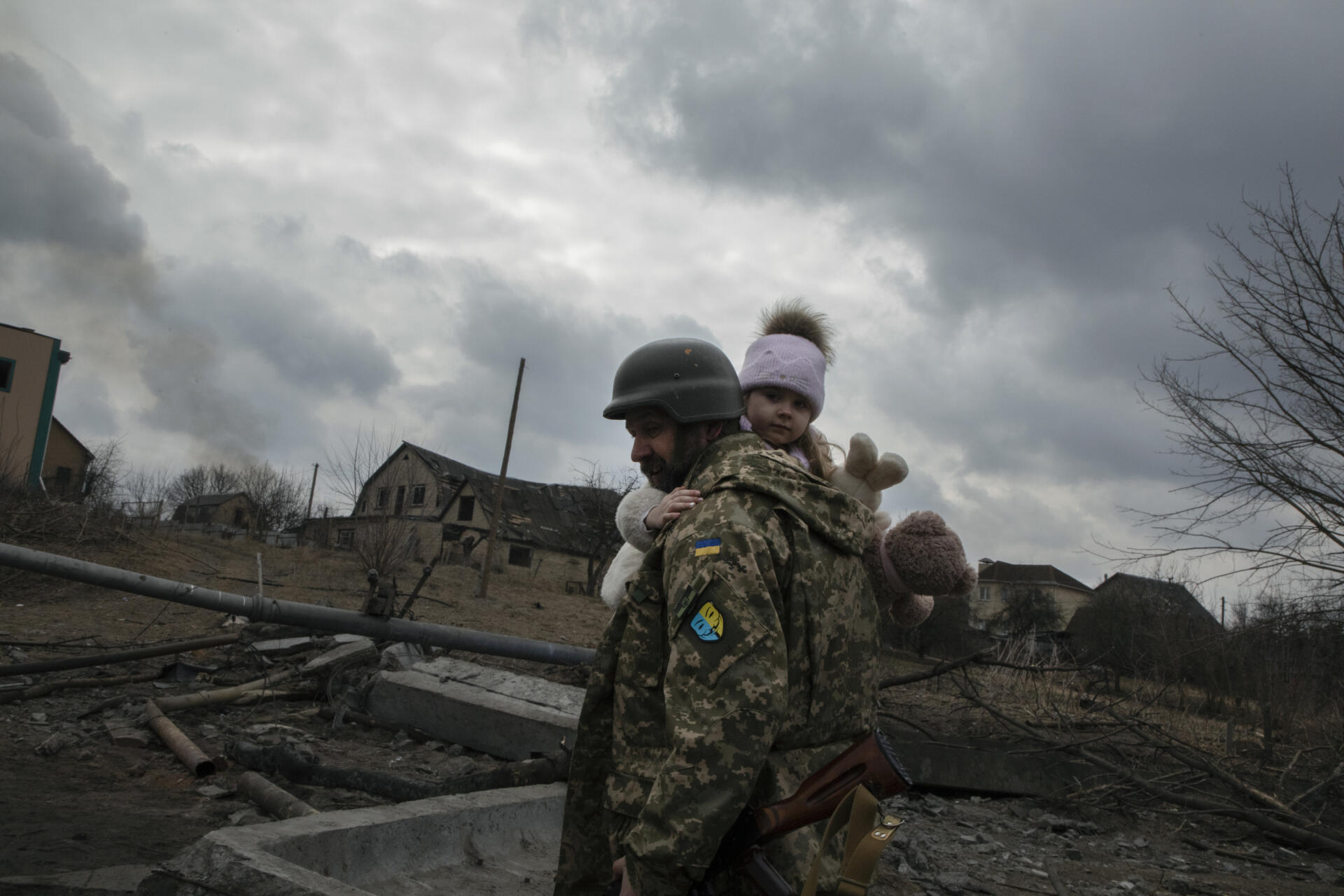 Un soldado lleva a una niña mientras los residentes de Irpin huyen por temor a la llegada del ejército ruso a Ucrania, el 6 de marzo de 2022.