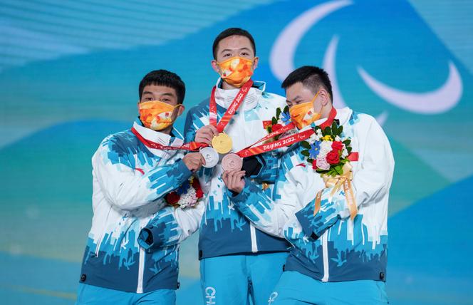 Le podium 100 % chinois en snowboardcross aux Jeux paralympiques de Pékin, le 7 mars. Les médaillés d’or Lijia Ji (centre), d’argent Pengyao Wang (gauche), et de bronze Yonggang Zhu.