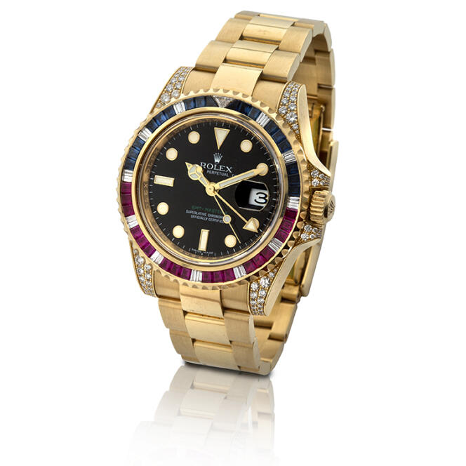 Montre-bracelet Rolex GMT-Master II en or jaune 18 carats, diamants, saphirs et rubis, estimée 50 000 euros, proposée lors de la vente en ligne de l’étude Aguttes de mars 2022.